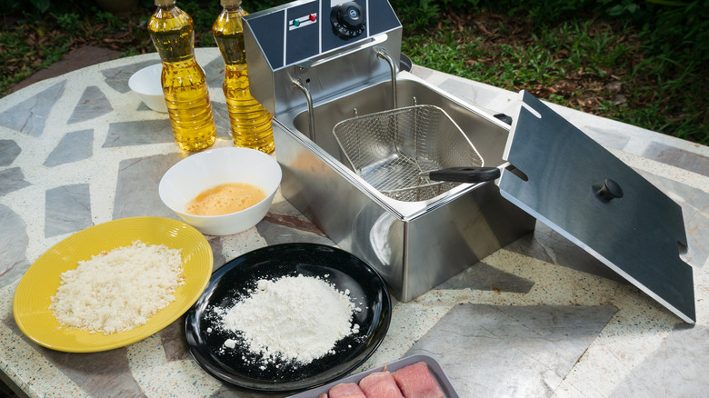 Electric deep fryer with ingredients for making tonkatsu stuffed with cheese
