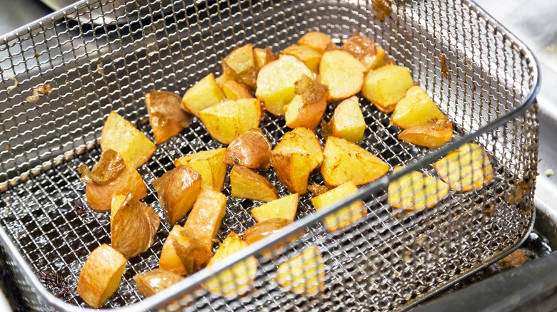 Deep fryer basket with fried potatoes