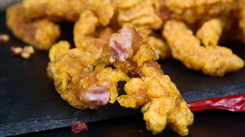 Crispy fried pork on a black granite surface