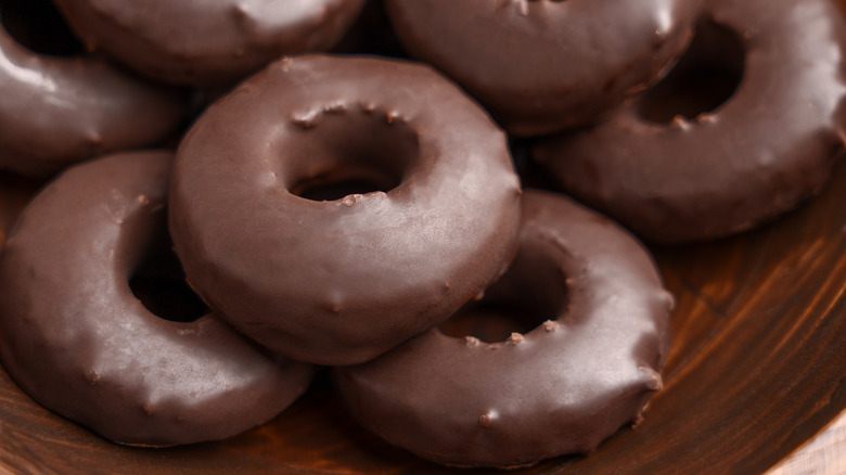 chocolate donuts piled on plate