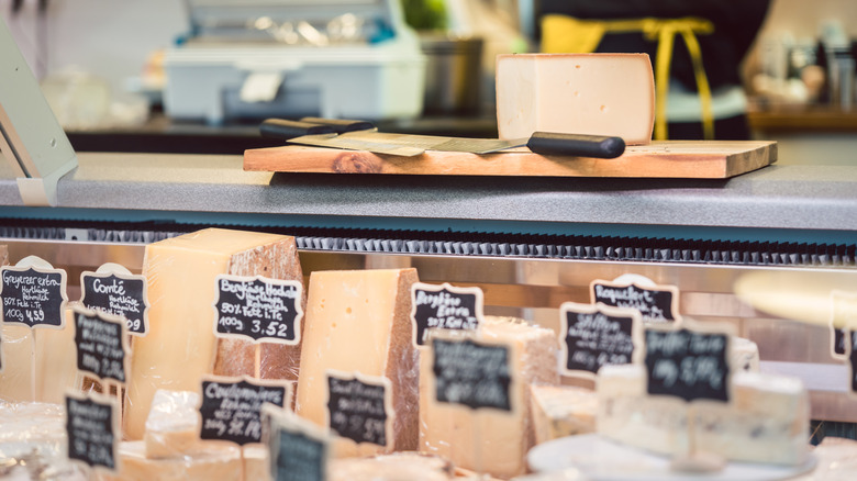 Soft and aged cheeses behind a deli counter