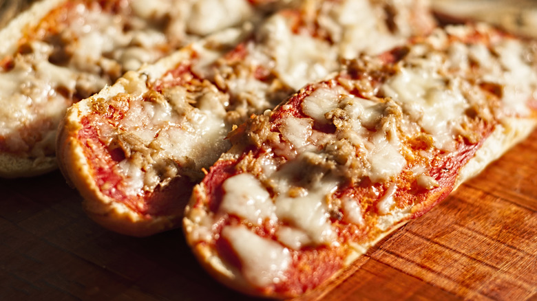 French bread pizza on a wooden cutting board