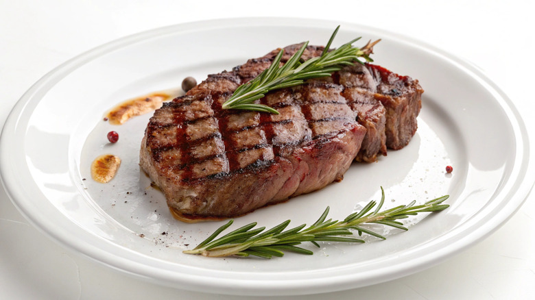 Steak on a white plate with rosemary