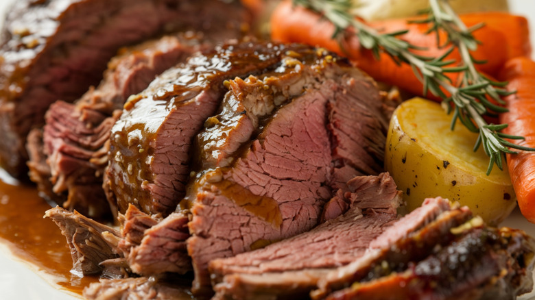 Close up of pot roast with vegetables and herbs