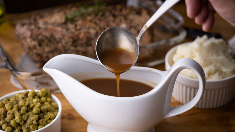 Gravy in a white gravy boat with a spoon