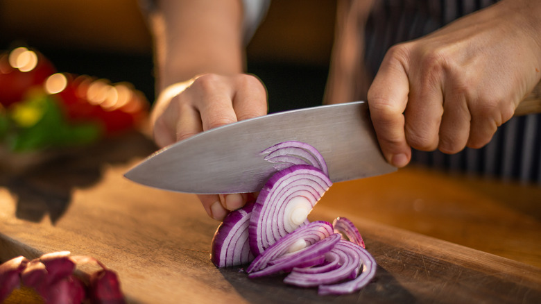 Onions being cut on a cutting board
