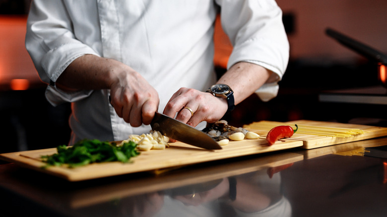 Chef cutting vegetables on a cutting board