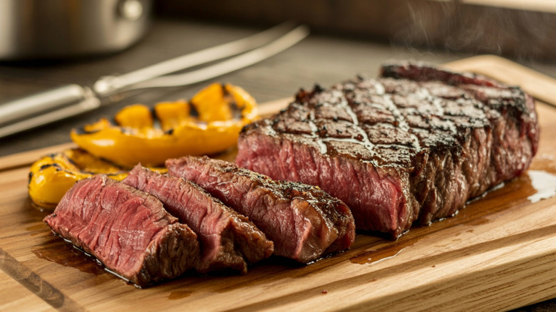 Grilled steak on a cutting board sliced across the grain
