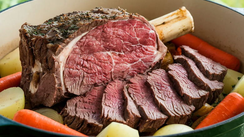 Slow-roasted prime rib with herb crust carved to reveal a medium-rare rosy pink interior