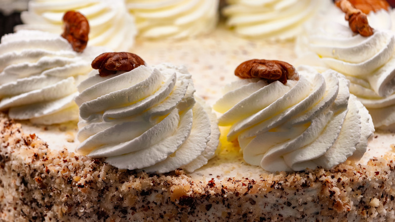 close-up of a cheesecake topped with swirls of cream and nuts