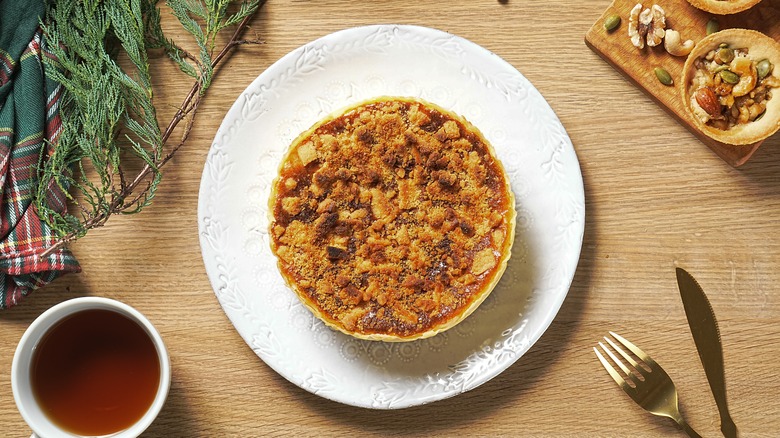 Apple crumble style cheese pie top view on a wooden table background.
