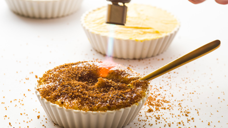 close up of a torch caramelising sugar on top of creme brulee