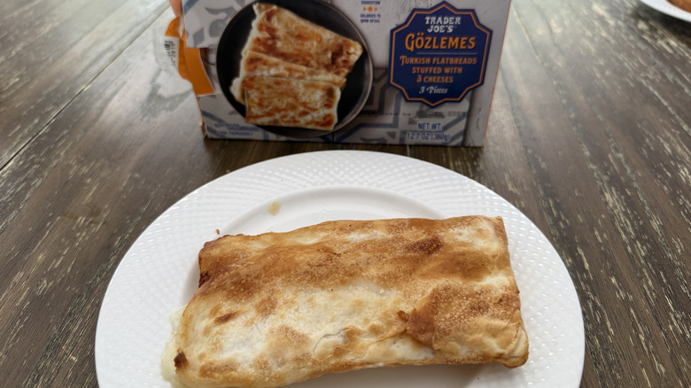 Package of Trader Joe's gozlemes on wooden table with one on a white plate
