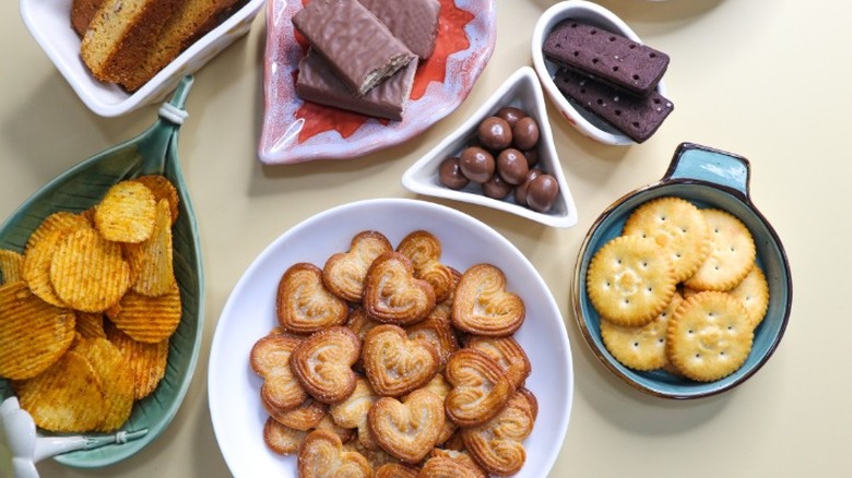 plates with chips, crackers, cookies, and chocolates