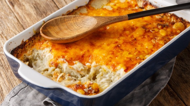 a cheesy casserole in a rectangular dish with a spoonful taken out