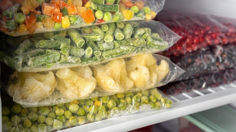 bags of assorted frozen vegetables on freezer shelf