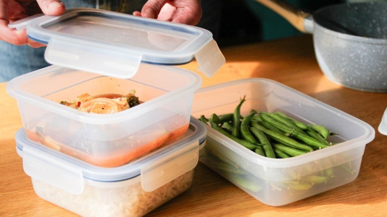 soup, rice, and edamame being packaged in plastic tupperware