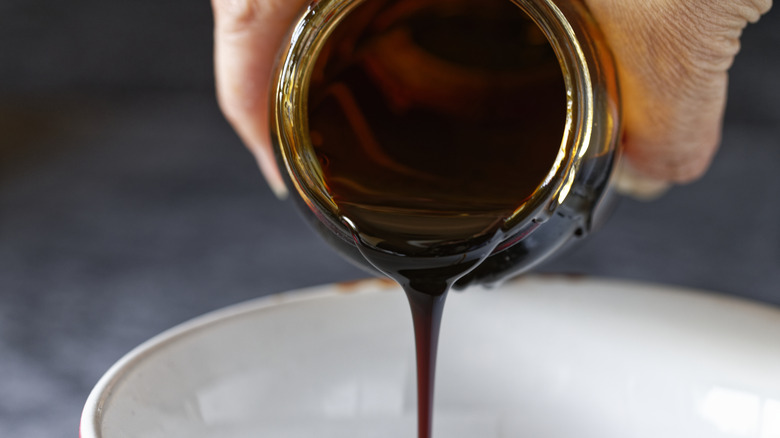 Person pouring molasses into a bowl