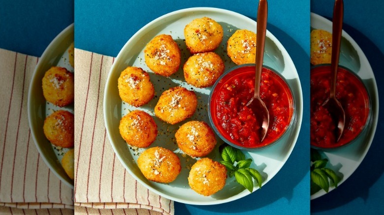 plate of bettergoods cacio e pepe arancini with cup of marinara sauce