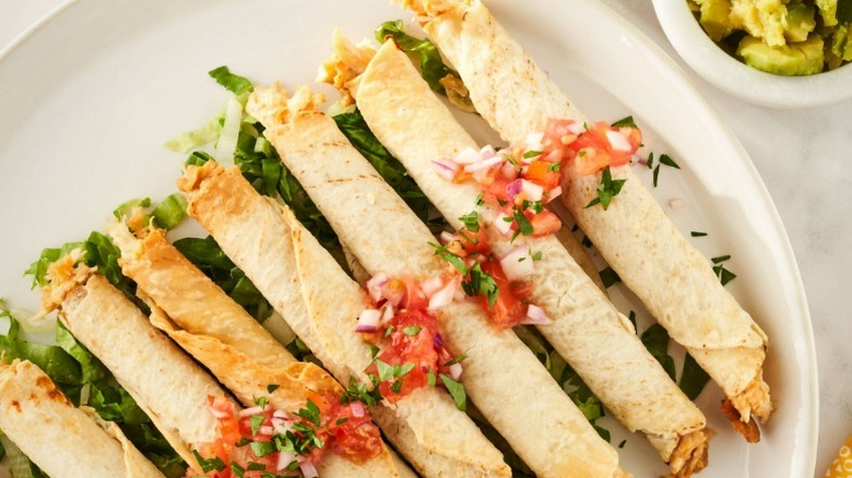 plate of Great Value chicken taquitos with salsa and shredded lettuce