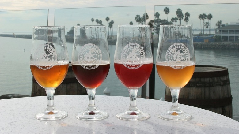 Four draft beers from Ballast Point with water in the background