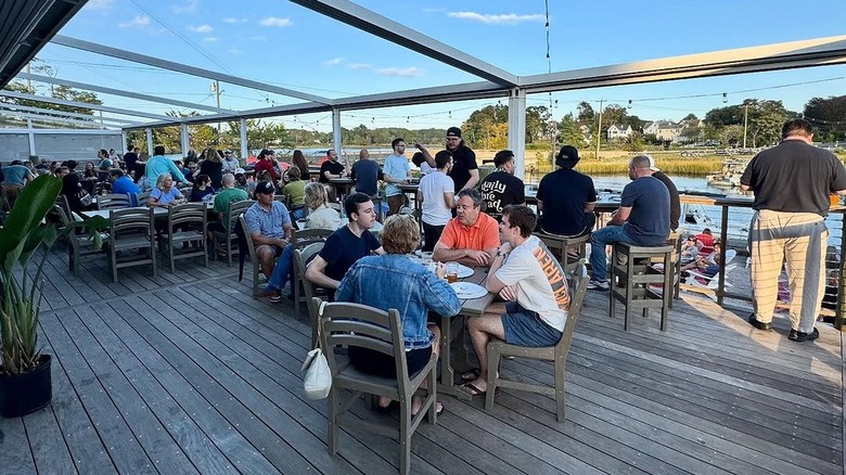 Patio of New England Brewing Company filled with customers
