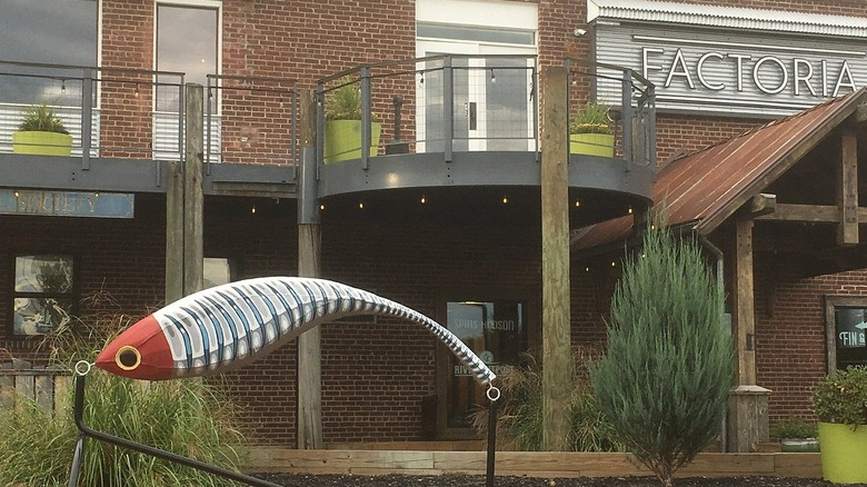 Exterior of River Outpost Brewing Co. in Peekskill, New York with a metal fish sculpture in the foreground