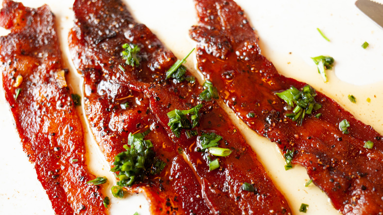 Strips of bacon brushed with maple syrup, brown sugar, herbs and spices