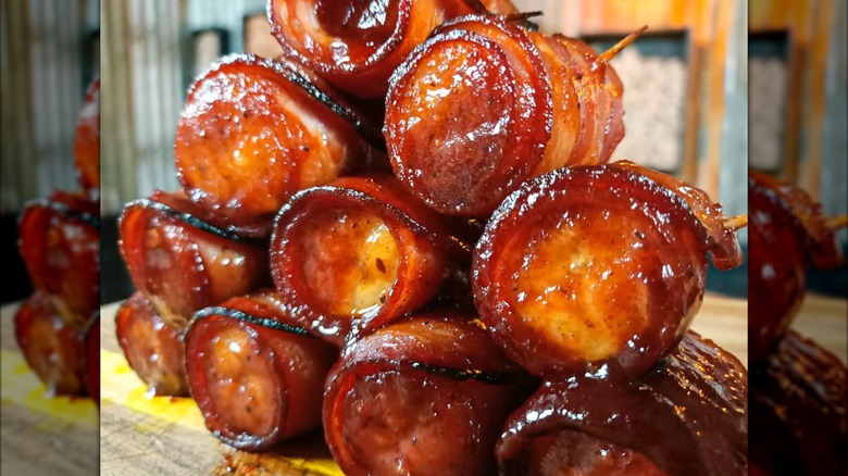 Greasy bacon wrapped banana pieces in pile with toothpicks