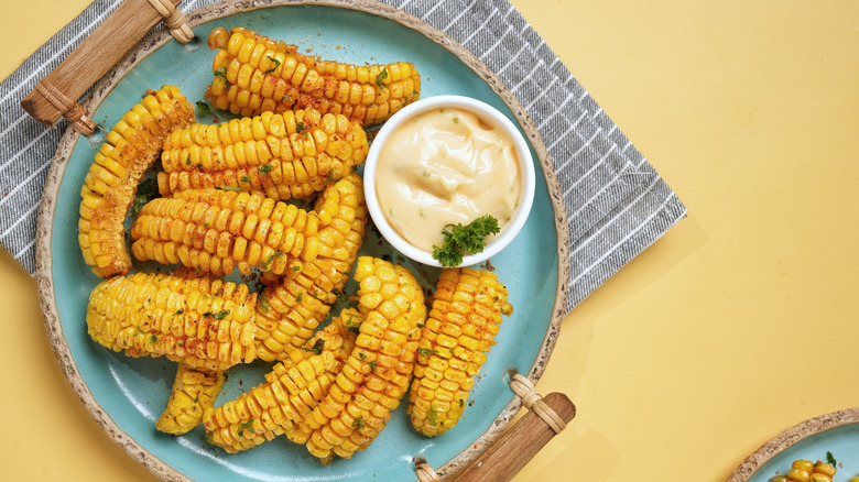 Fried corn riblets on a blue plate with sauce