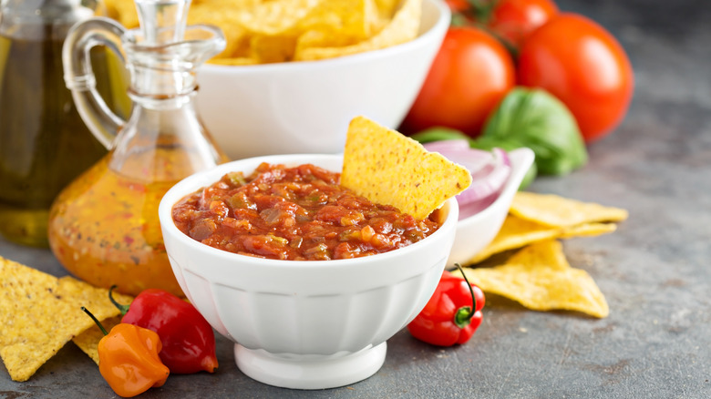 A white bowl of salsa with tortilla chips