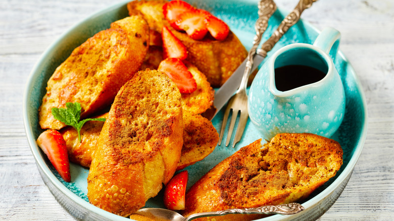 Cinnamon French toast with strawberry slices and maple syrup