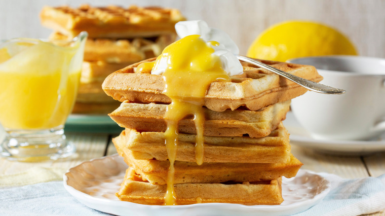 A stack of waffles topped with lemon curd