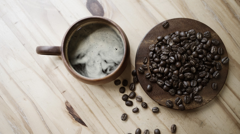 Cup of brewed coffee and coffee beans