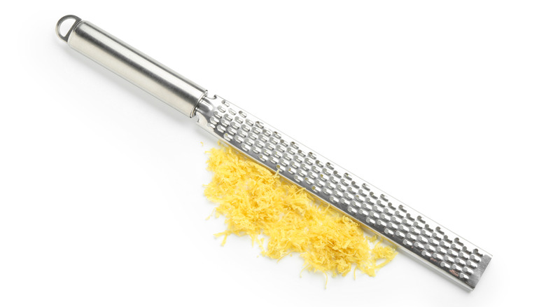 A lemon zester on a white backdrop