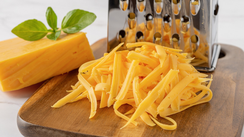 A metal grater and shredded cheese