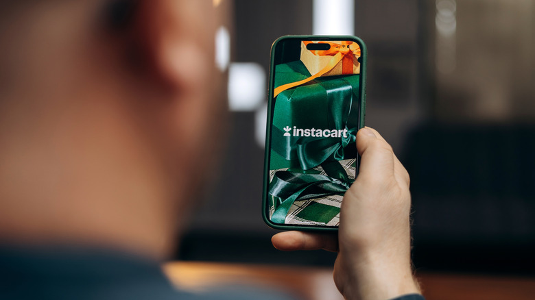 A shopper using instacart on smartphone to order groceries
