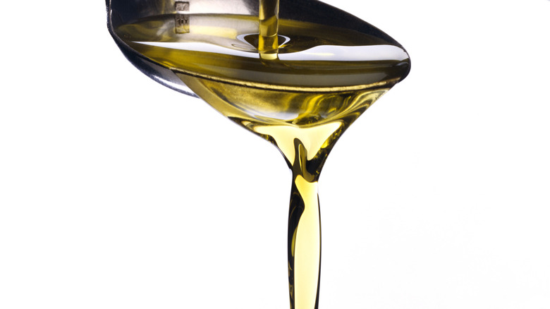Olive oil being poured onto a spoon