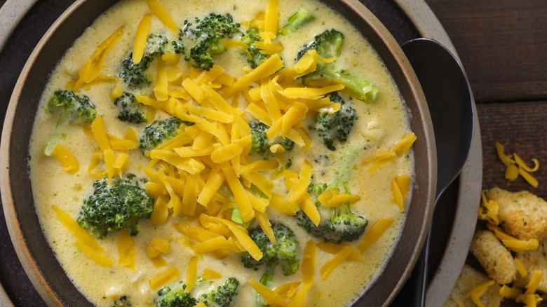 Grated yellow cheese topping broccoli soup