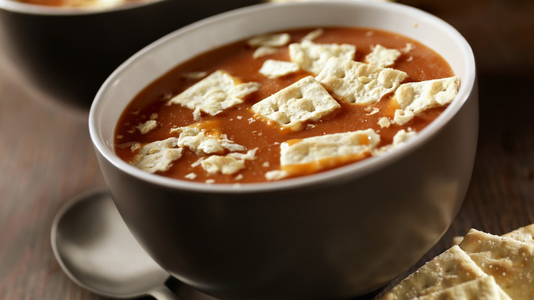 Bowl of tomato soup topped with crackers