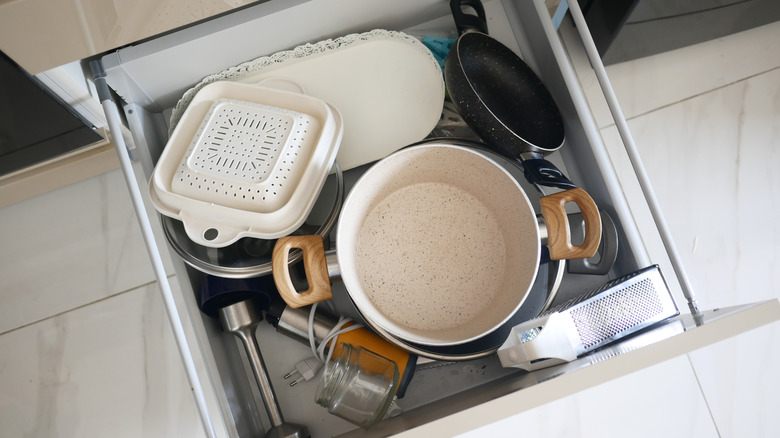 a kitchen drawer overflowing with unused cookware and gadgets