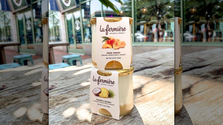 Two pots of La Fermière yogurt stacked on wooden table