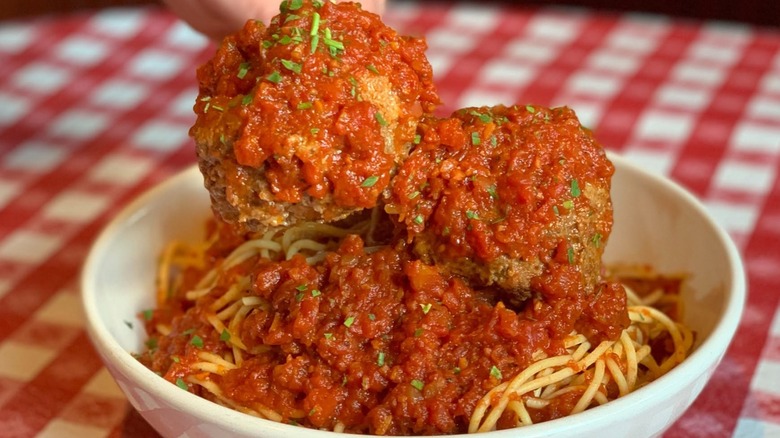A large white bowl of spaghetti meatballs.