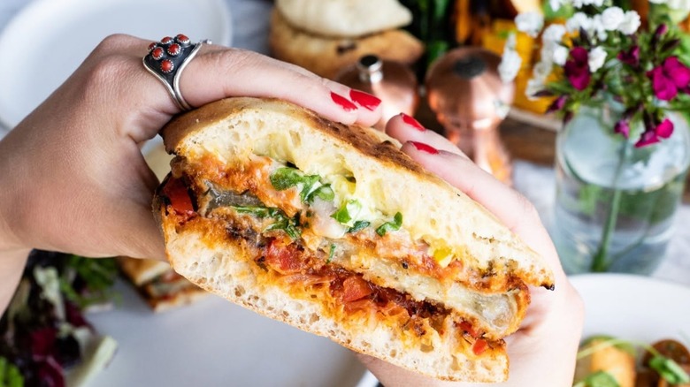 Someone holding an Italian-style sandwich with both hands.