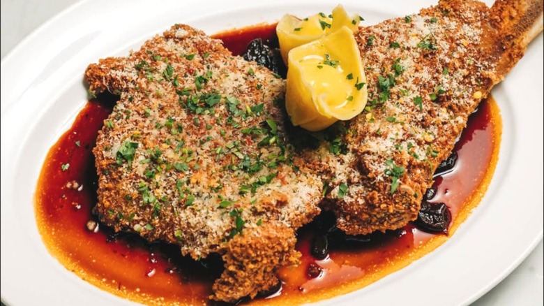 A large cut of crusted veal on a white plate.