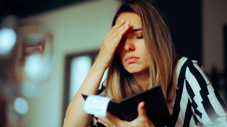 Unhappy woman receiving an overpriced bill in a restaurant