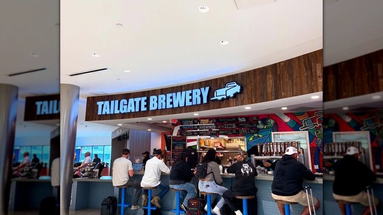 Multiple people sitting at Tailgate Brewery's bar inside Nashville International Airport