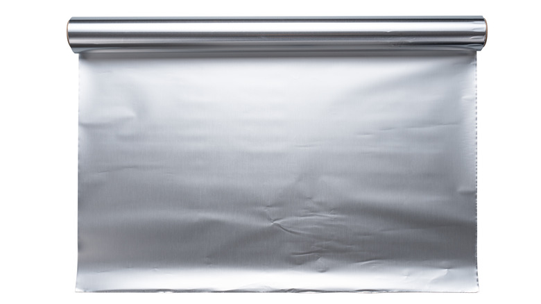 A roll of aluminum foil with a sheet pulled down