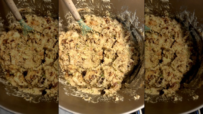 Close up of mixing bowl filled with PA Dutch Potato Filling being stirred with a wooden spoon