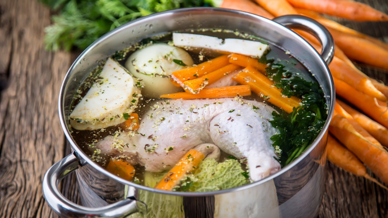 chicken and veggies in a pot of water